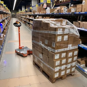 360Mover gekoppelt an Handhubwagen mit Palette in der Kommissionierung.