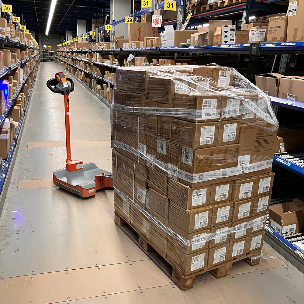 360Mover gekoppelt an Handhubwagen mit Palette in der Kommissionierung.